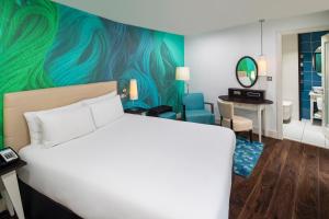 リバプールにあるホテル インディゴ リバプールのベッド、デスク、鏡が備わる客室です。