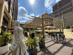 eine Statue einer Frau in einem Hof mit Pflanzen in der Unterkunft Copthorne Tara Hotel London Kensington in London