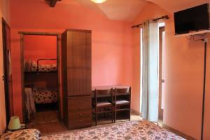 um quarto com paredes cor-de-laranja, uma cómoda e um espelho. em Locanda monte cervino em Antey-Saint-André