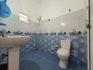 a blue and white bathroom with a toilet and a sink at Sa Rest Inn in Haputale