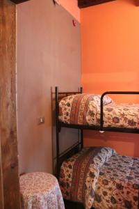 a room with two bunk beds and an orange wall at Locanda monte cervino in Antey-Saint-André