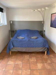 um quarto com uma cama azul com duas toalhas em Mysigt gästhus med cykelavstånd till havet! em Skivarp