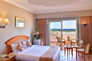 Sharm Grand Plaza Resort - Families and Couples Only في شرم الشيخ: غرفة فندقية بسرير وطاولة وكراسي