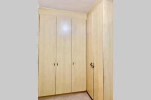 a closet with wooden cabinets in a room at Waters Breakaway in Bloubergstrand