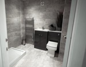 La salle de bains est pourvue de toilettes, d'un lavabo et d'une baignoire. dans l'établissement The Old Fire Station, à Kelso