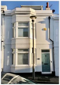 ein weißes Haus mit einem davor geparkten Auto in der Unterkunft Blue Haven in Brighton & Hove