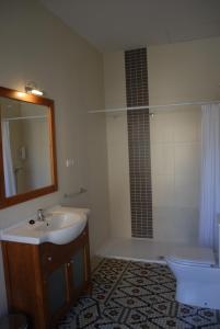 グラナダにあるLa Perla Granada Suitesの洗面台、トイレ、鏡のあるバスルーム