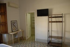 a room with a bed and a television on a wall at La Perla Granada Suites in Granada