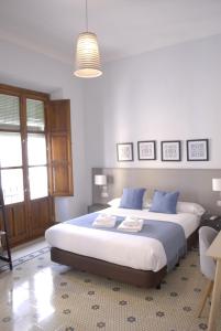 una camera da letto con un grande letto con cuscini blu di La Perla Granada Suites a Granada