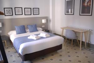 Habitación de hotel con cama y escritorio en La Perla Granada Suites, en Granada