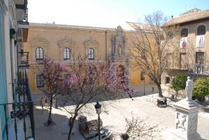 a courtyard of a building with trees in front of it at La Perla Granada Suites in Granada