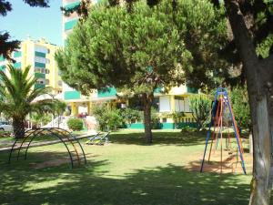 um parque infantil num parque com dois baloiços em Parque das Amendoeiras em Vilamoura