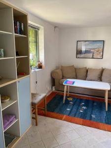 uma sala de estar com um sofá e uma mesa em Mysigt gästhus med cykelavstånd till havet! em Skivarp