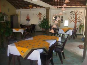 a dining room with tables and chairs and a painting on the wall at Hilda Guest House in Hikkaduwa