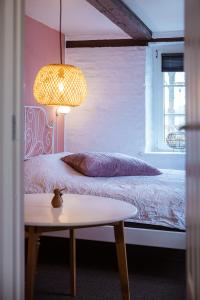 a bedroom with a bed with a table and a lamp at Lindegaarden Kollund in Kruså