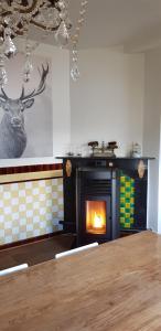 a kitchen with a fireplace with a deer on the wall at Gite L'éternité in Heure