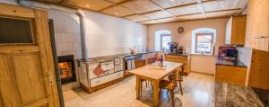 a large kitchen with a table and a fireplace at Ferienhaus Tuxerhof in Achenkirch