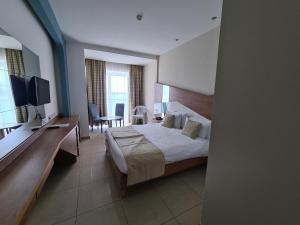 a hotel room with a bed and a desk at Water's Edge Hotel in Birżebbuġa