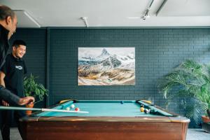 a man standing next to a pool table at Hostel by Hyve Basel in Basel