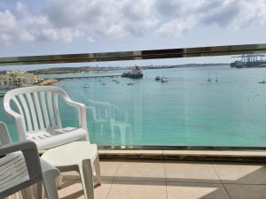 a balcony with a view of the water at Water's Edge Hotel in Birżebbuġa