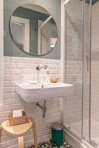 een witte badkamer met een wastafel en een spiegel bij La Lu cozy rooms 2 - Self check-in in Pisa