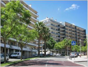 um grande edifício de apartamentos com carros estacionados num parque de estacionamento em Luxury ApartHotel Colinas do Cruzeiro em Odivelas