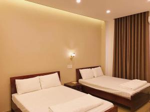 a hotel room with two beds and a window at Vân Trang Hotel in Vĩnh Long +57 photos