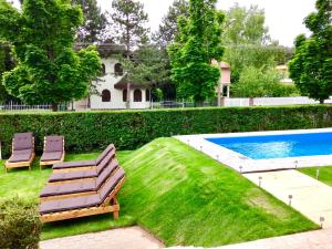 um quintal com duas espreguiçadeiras e uma piscina em Villa 55 & Pool - Siófok em Siófok