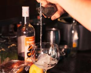 a person is pouring wine into a wine glass at Chetzeron Mountain Hotel in Crans-Montana