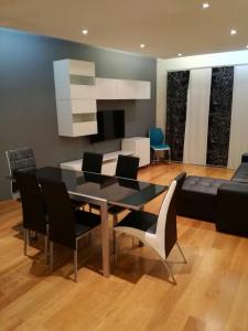 uma sala de jantar com uma mesa e cadeiras e um sofá em Luxury ApartHotel Colinas do Cruzeiro em Odivelas