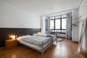 - une chambre avec un lit et une grande fenêtre dans l'établissement Kontxa Guesthouse, à Saint-Sébastien