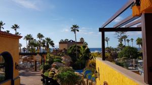 a view of a resort with palm trees and the ocean at Europe Villa Cortes GL in Playa de las Americas