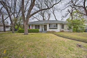 une maison blanche avec un arbre dans la cour dans l'établissement Creekside Home with Patio and Grill 17 Mi to Dallas!, à Garland