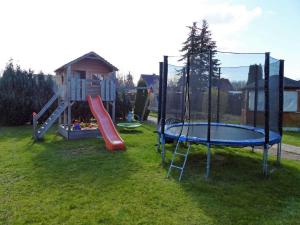 un parque infantil con tobogán y cama elástica en Ferienglück in Strandbadnähe von Waren Müritz en Waren