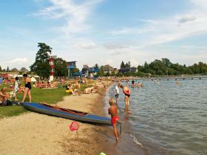 eine Gruppe von Menschen am Strand mit einem Boot in der Unterkunft Ferienglück in Strandbadnähe von Waren Müritz in Waren (Müritz)