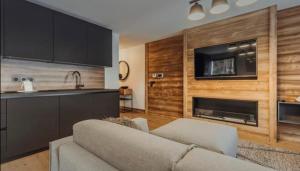 a kitchen and a living room with a couch and a fireplace at Interlude Megeve in Megève