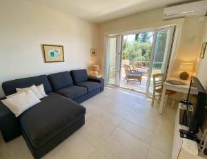 un soggiorno con un divano blu e un patio di Paleopetres K-Eight - Premium Suite - Kalami - a Kalámi