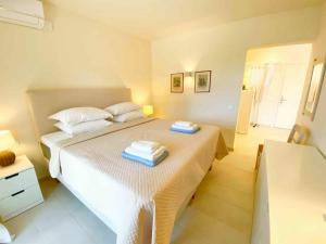 una camera da letto con un letto bianco con asciugamani sopra di Paleopetres K-Eight - Premium Suite - Kalami - a Kalámi Altre 65 foto