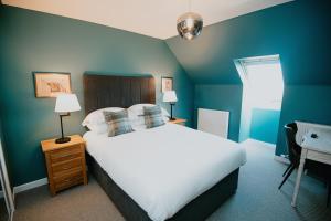 1 dormitorio con cama blanca y pared azul en The Seafield Arms Hotel Cullen - Self Catering, en Cullen
