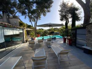 a patio with tables and chairs and a swimming pool at Inn 4 Bears in Nîmes
