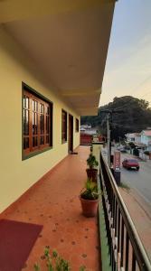 a balcony of a building with potted plants on it at IMPERIAL COTTAGE, HILL BUNK OOTY in Ooty