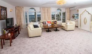 a living room with couches and a table and a tv at Hotel Princess Residence in Kiten