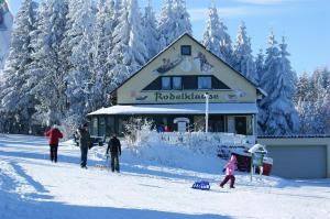 een groep mensen in de sneeuw voor een gebouw bij Ferienhaus Schelle in Kurort Altenberg