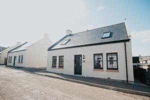 a row of white buildings on a street at The Seafield Arms Hotel Cullen - Self Catering in Cullen