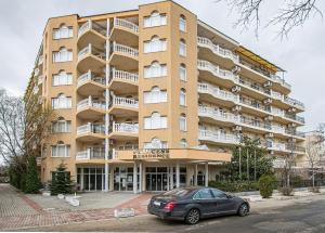 a car parked in front of a large building at Hotel Princess Residence in Kiten