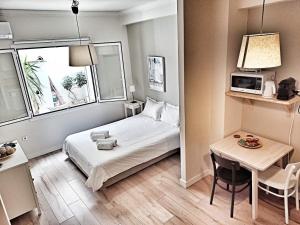 a hotel room with a bed and a table and a kitchen at Artemis Apartment @ Plaka in Athens