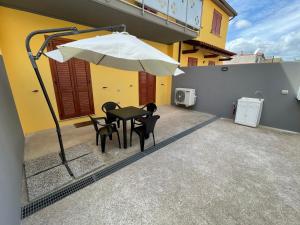 a patio with a table and chairs and an umbrella at Alex Apartment Pula in Pula