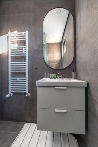 a bathroom with a white sink and a mirror at Industrial 2-BDR Flat by the National Stadium in Sofia
