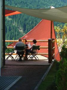 zwei Personen, die an einem Tisch unter einem Zelt sitzen in der Unterkunft Hotel Ca' del Bosco in Selva di Cadore