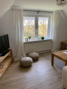 sala de estar con TV y ventana en Ferienwohnungen am Aussendeich en Nordstrand